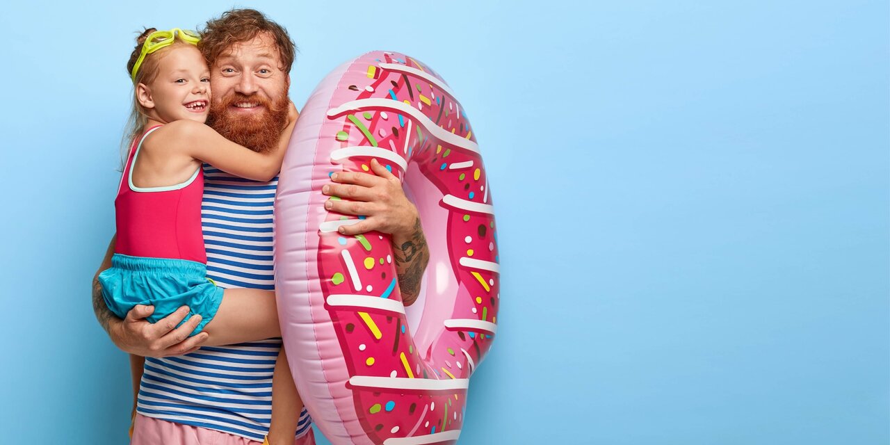 Fürsorglicher Vater und Tochter mit Schwimmreifen Foto zeigt fürsorglichen Vater und Tochter mit Schwimmreifen.